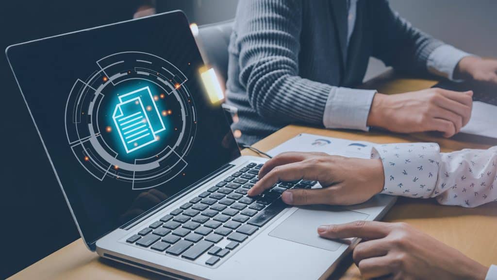 Business professional working on a laptop with digital file and data security interface representing managed IT services and secure document management